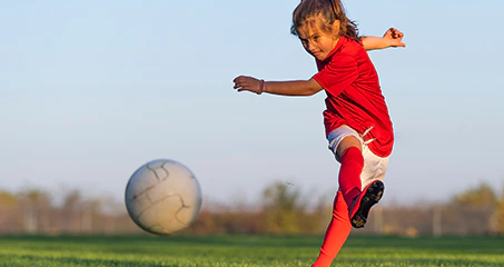 Nena jugant un partit de futbol